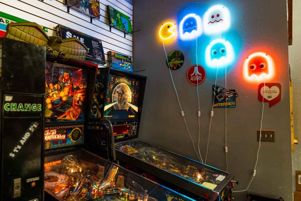 Pinball Machines With Pacman Neon Lights on the wall