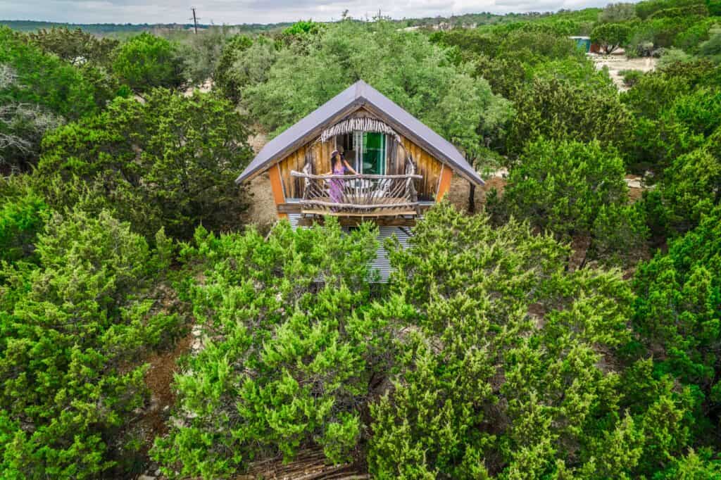 Birdhouse like cabin surrounded by trees