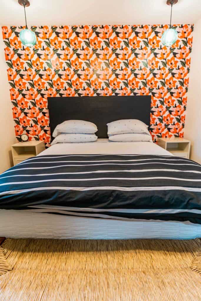 A bed with a black and white striped headboard