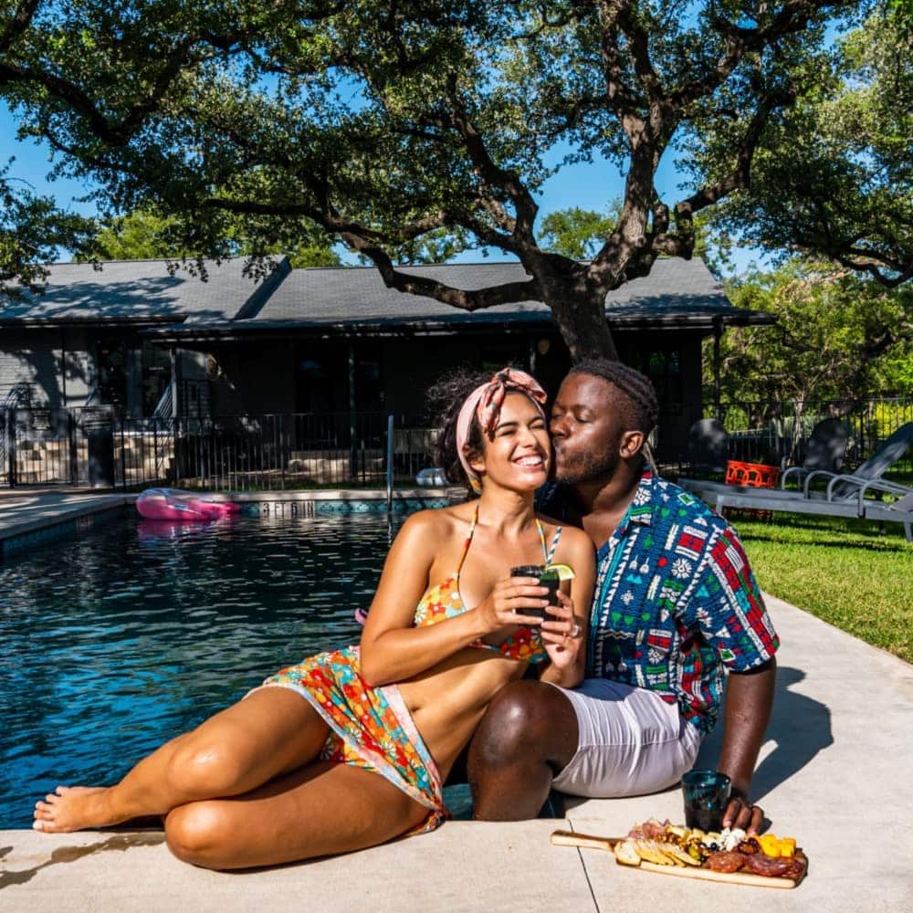 Poolside couple with a charcuterie board and cocktails