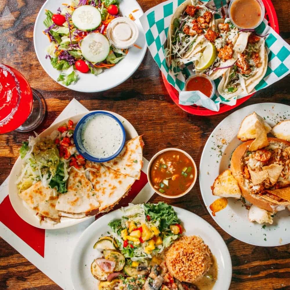 Plates laid out on a table with different Mexican food dishes
