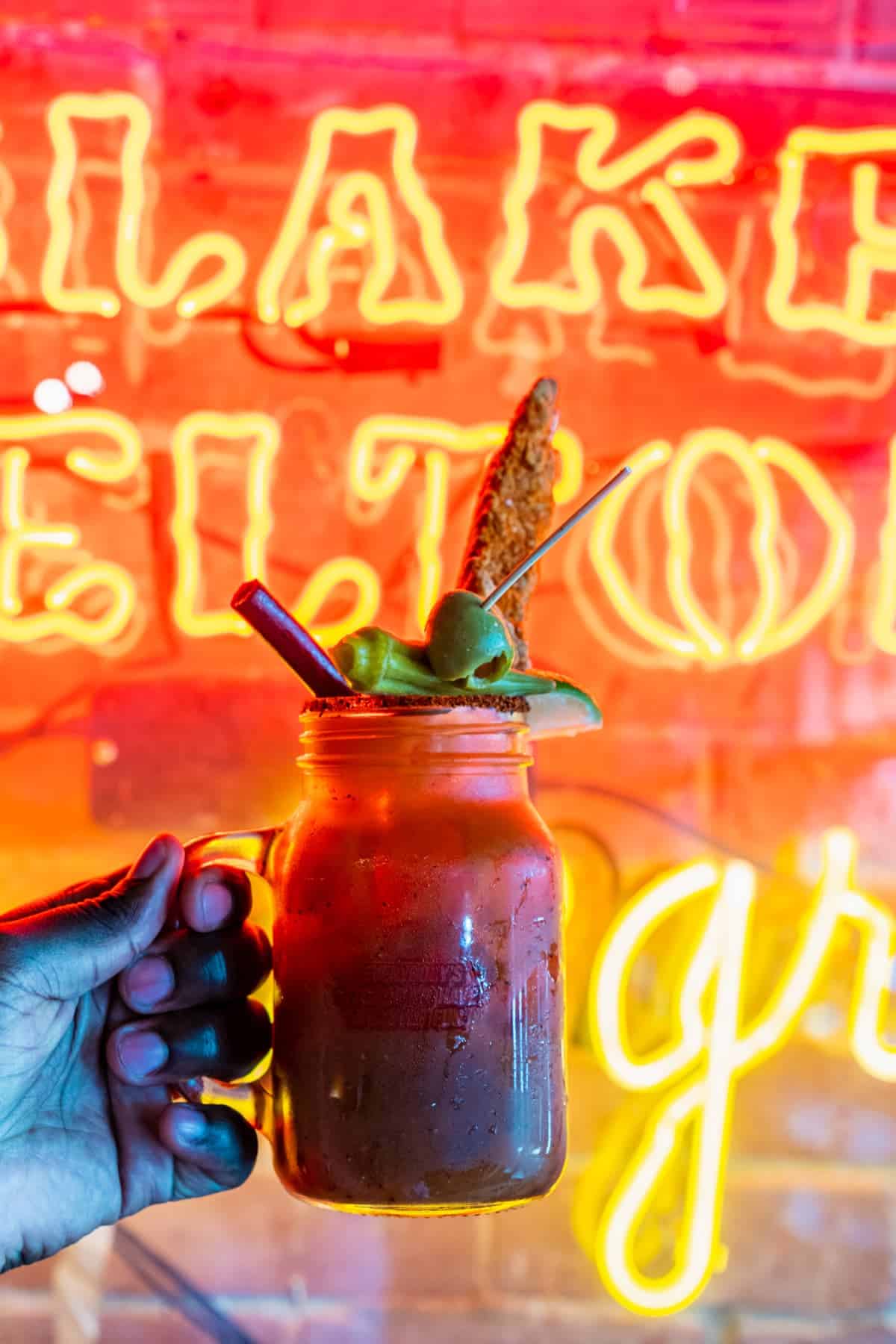 Bloody Mary topped with a chicken strip and in a souvenir mason jar mug