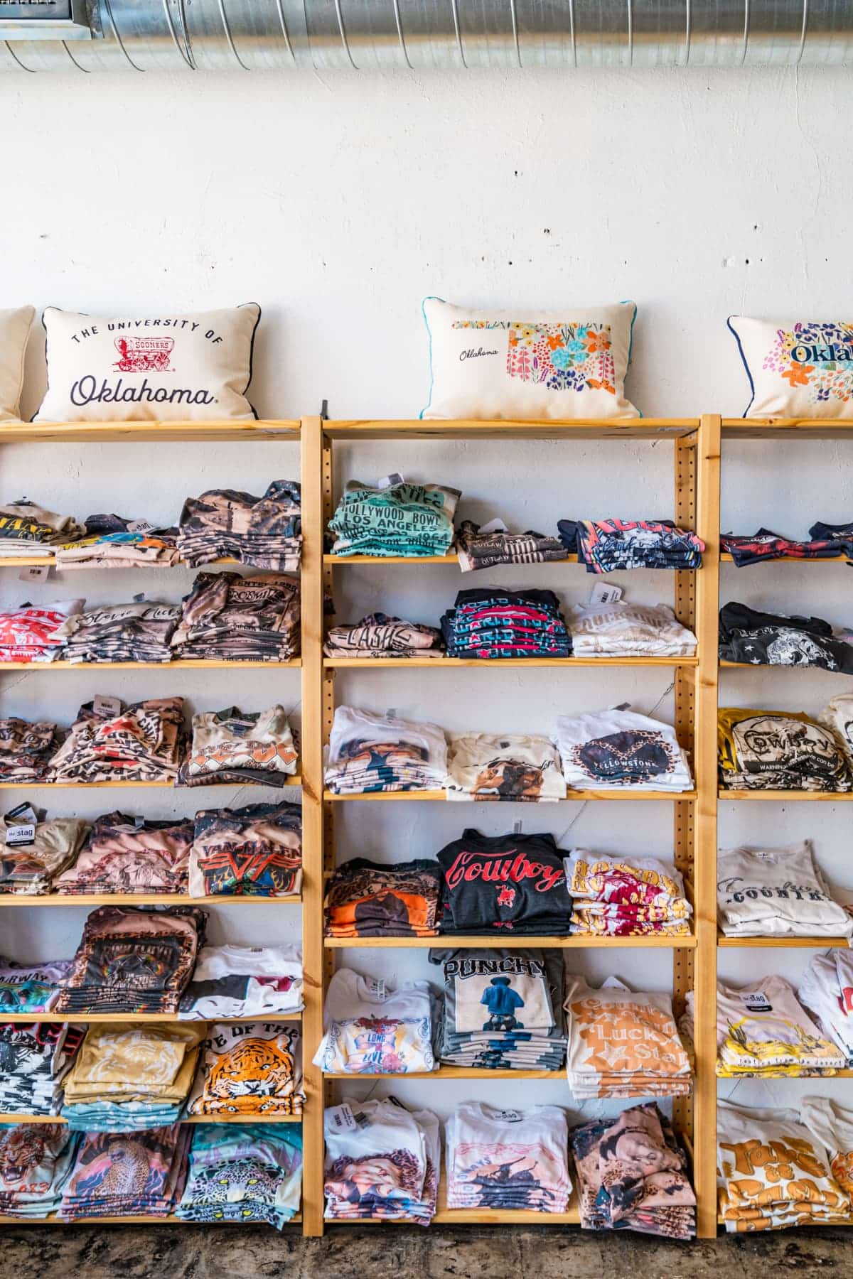 Shelves of folded graphic tees at The Stag