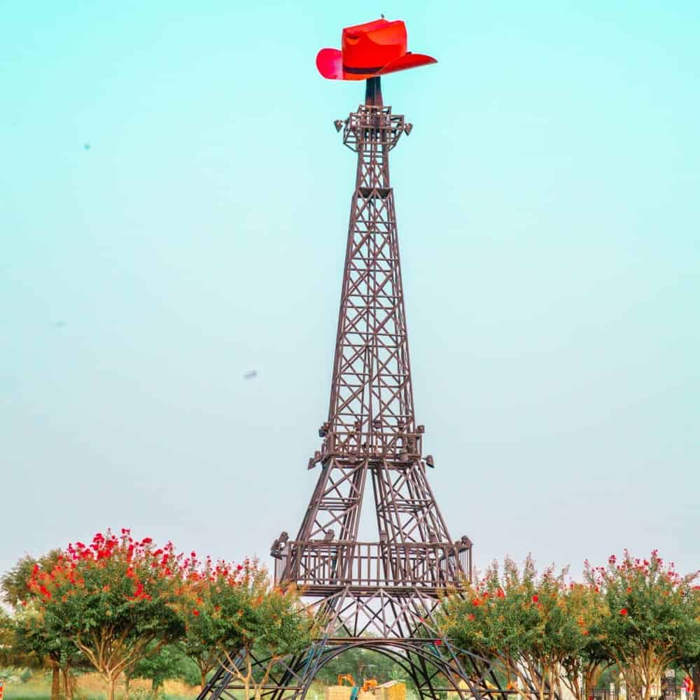 Eiffel Tower with a red cowboy hat on top of it