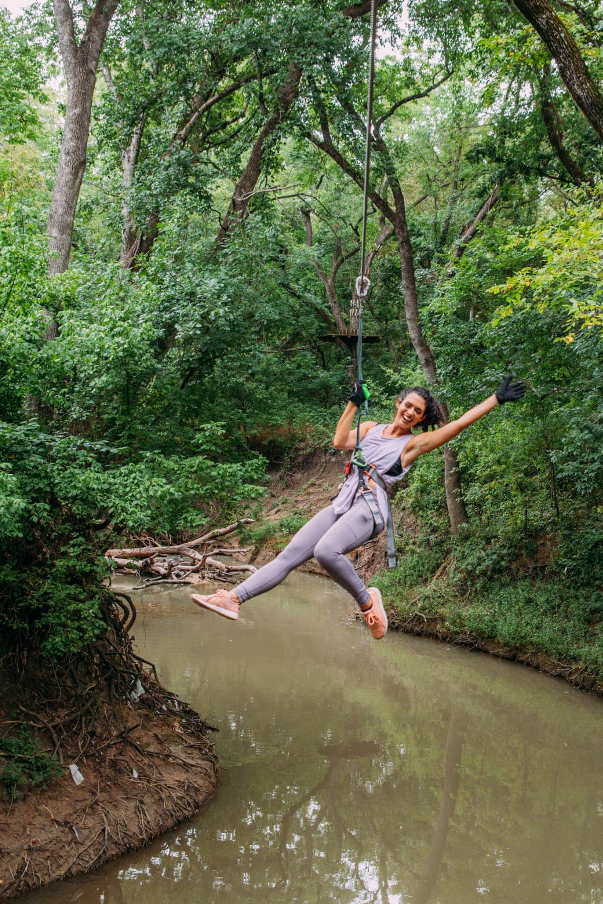 Woman suspended over a river in a climbing harness