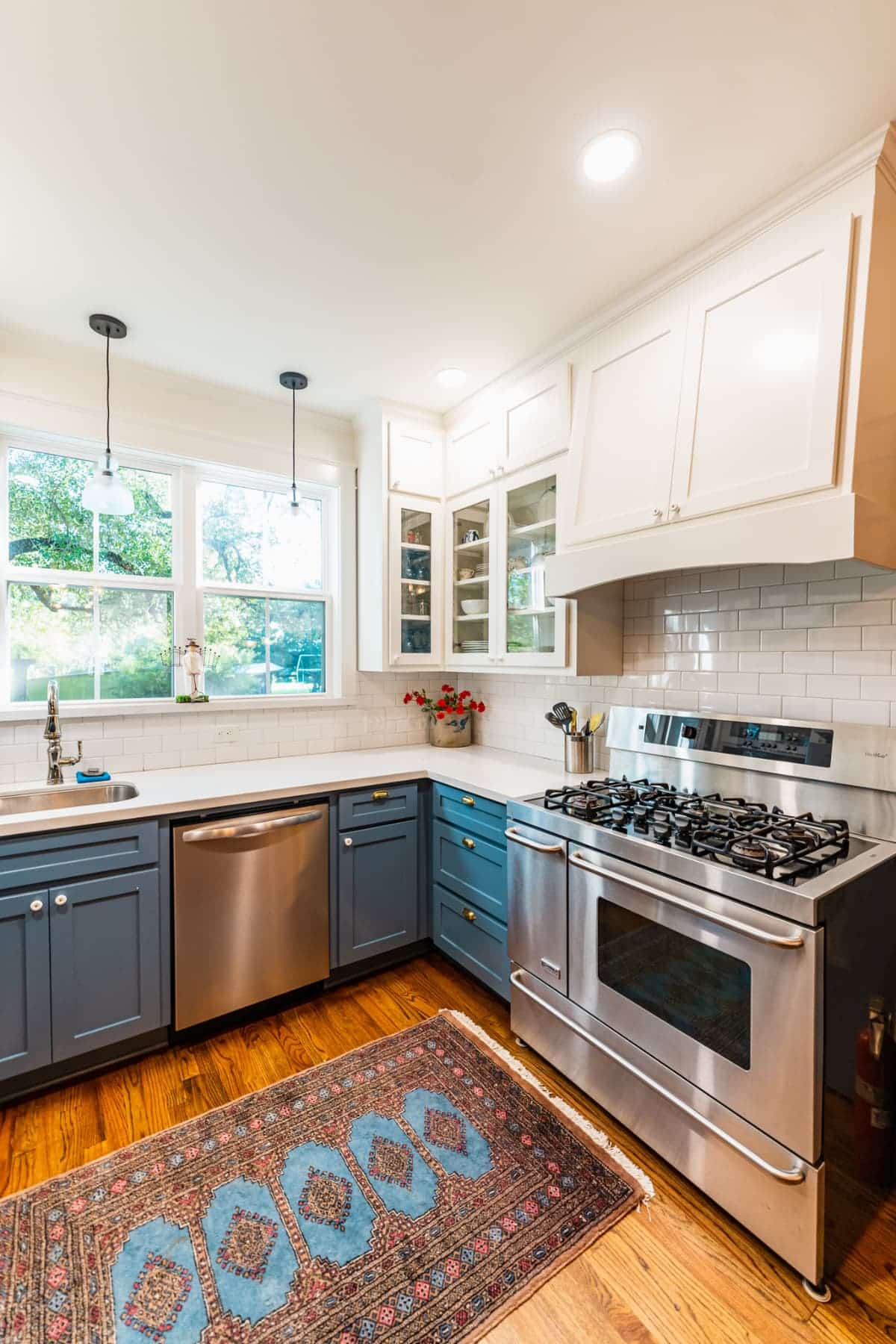 Full kitchen inside the cottage with stainless steel appliances and blue cabinets
