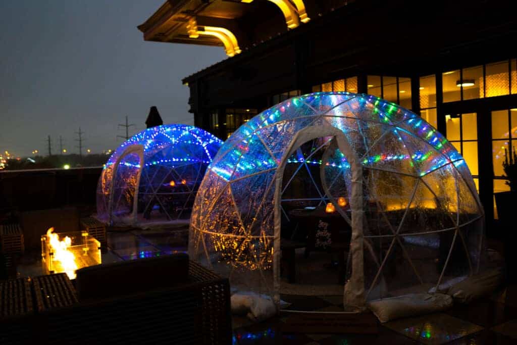 a two igloos with lights on outside of a building Christmas bars Dallas