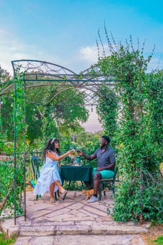 a couple sitting at a table under a pergola