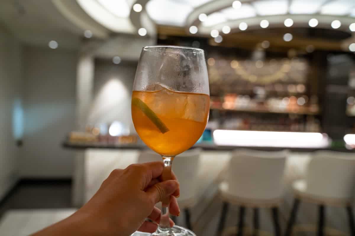 Woman holding a glass of wine in front of the bar