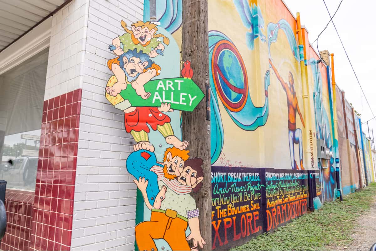 Sign that says Art Alley and walls covered in bright murals