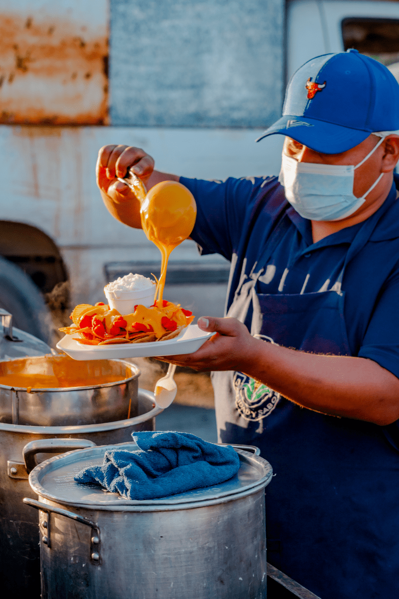 Vendor Pouring a cheese on a snack plate