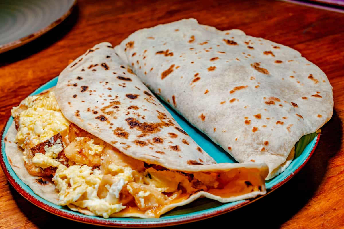 Two huge breakfast tacos on a plate