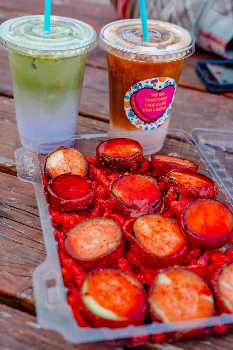 Colorful coffees with a tray of chamoy covered cucumbers