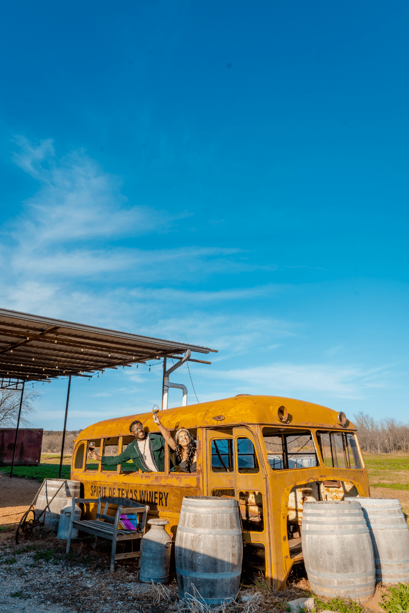 Couple posing inside an old yellow bus