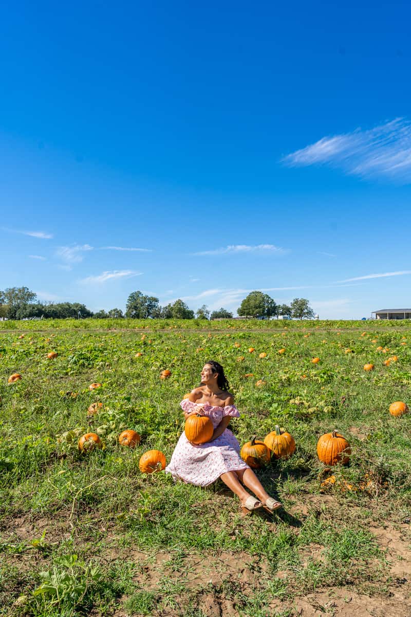 Woman sitting in a pumpkin patch
