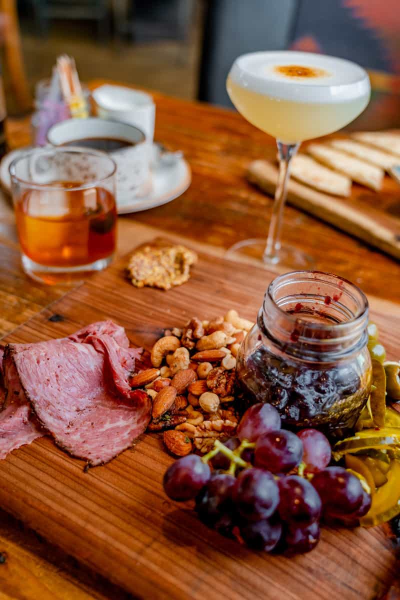 Build your own board with meat, nuts, jam, and two cocktails