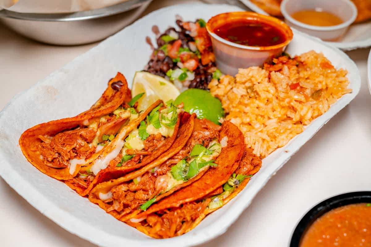 Plate of vegan Birria tacos with a side of rice and beans