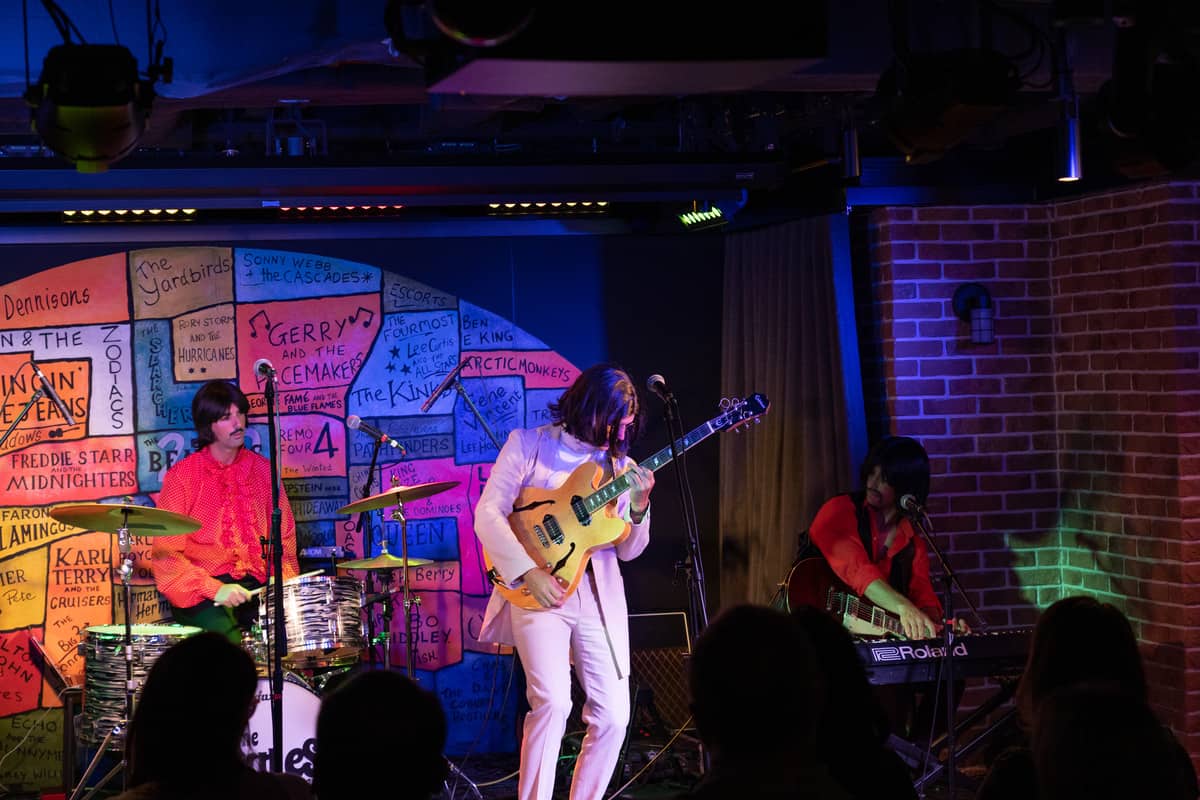 Band on-stage dressed at The Beatles on the norwegian bliss ship