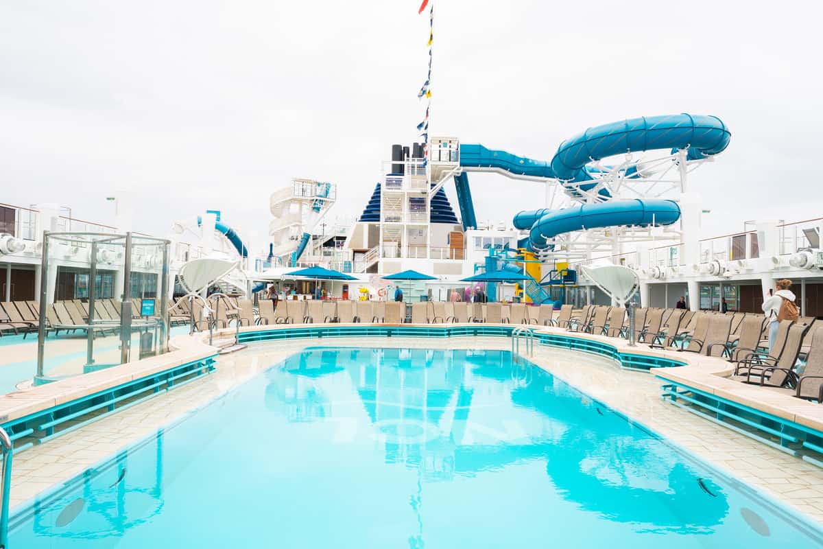 Main pool area with sunning chairs and slides in the background