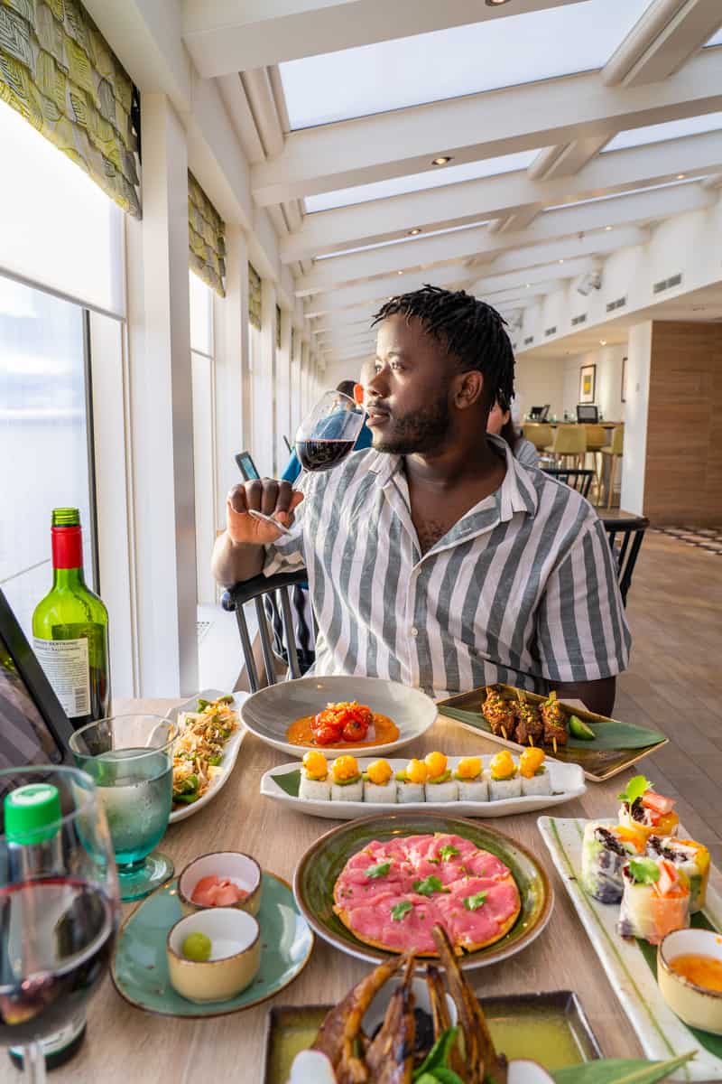 Man eating and looking out over the ocean from the cruise ship dining room