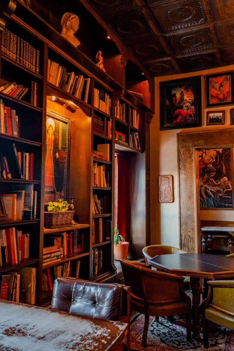 Wall-to-ceiling bookshelf with antique photos on the wall