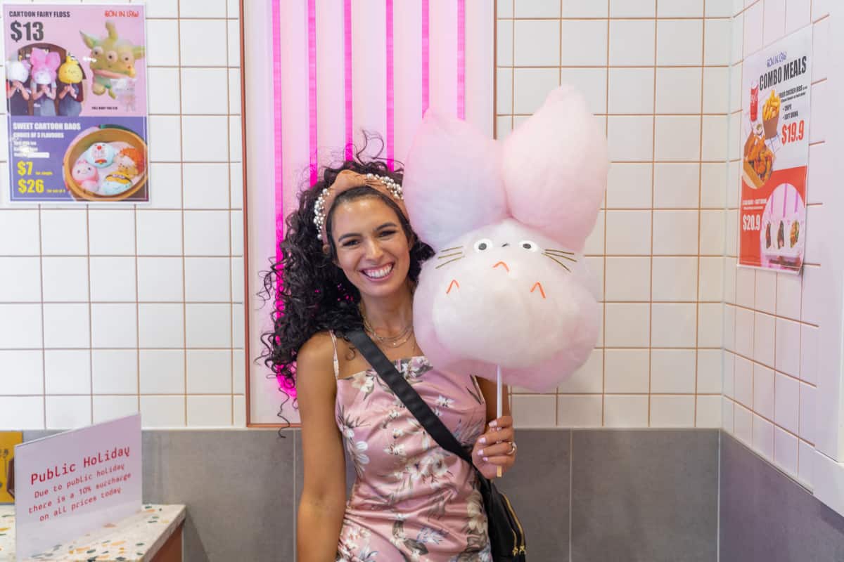 Woman holding a huge cotton candy rabbit on a stick
