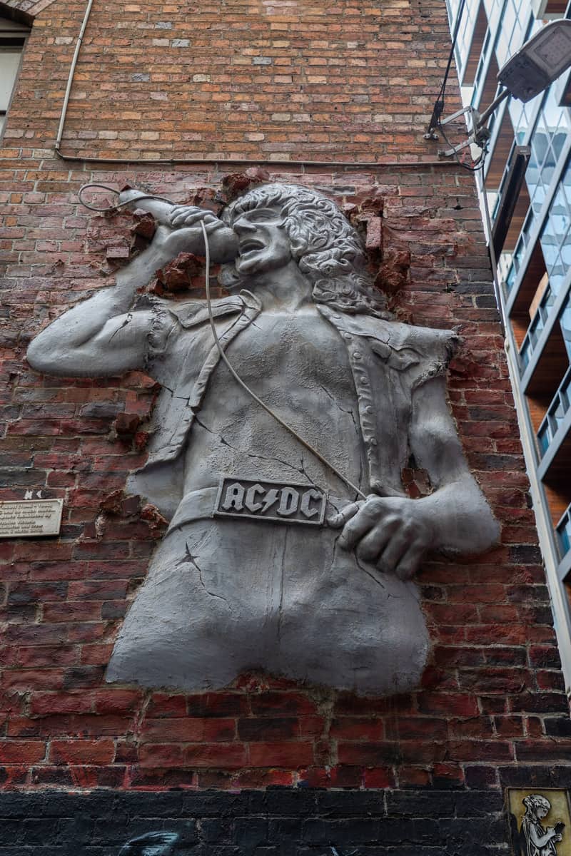 3D mural of Angus Young on a brick wall