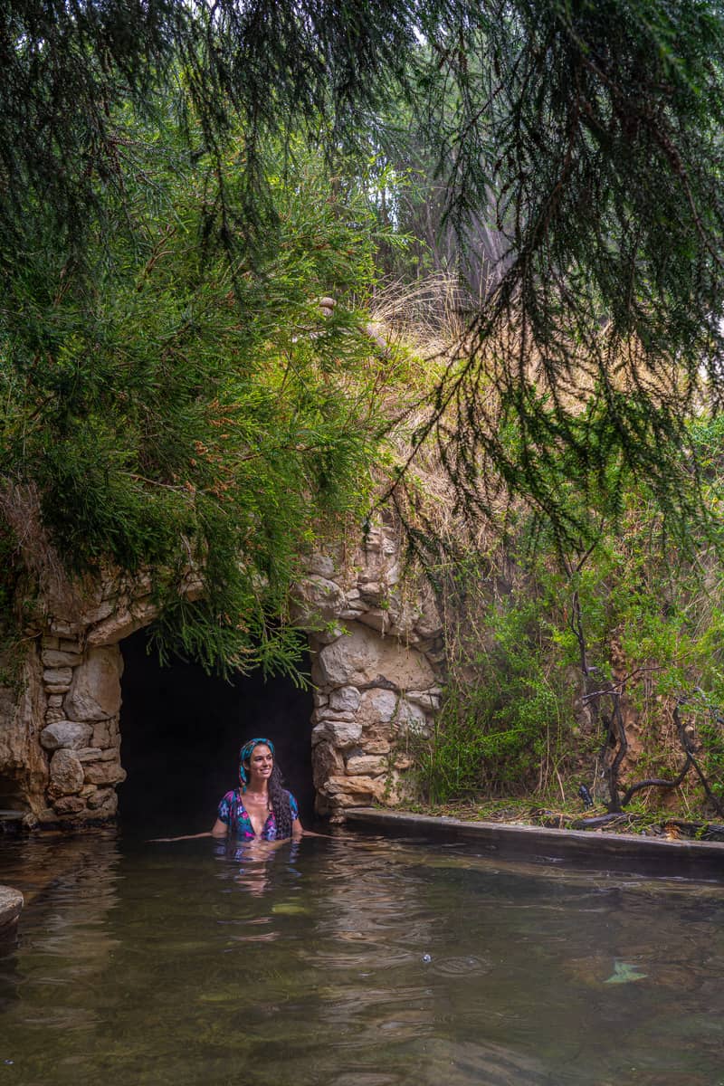 Woman standing in a pool under a tree