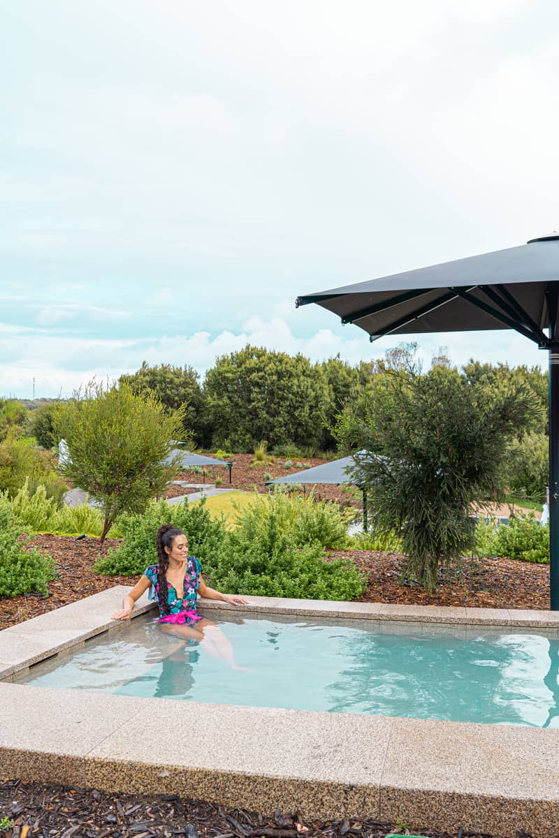 Woman sitting in a pool overlooking nature