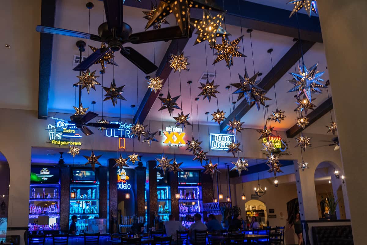 Dining room with neon blue lighting and lights shaped like stars hanging from the ceiling