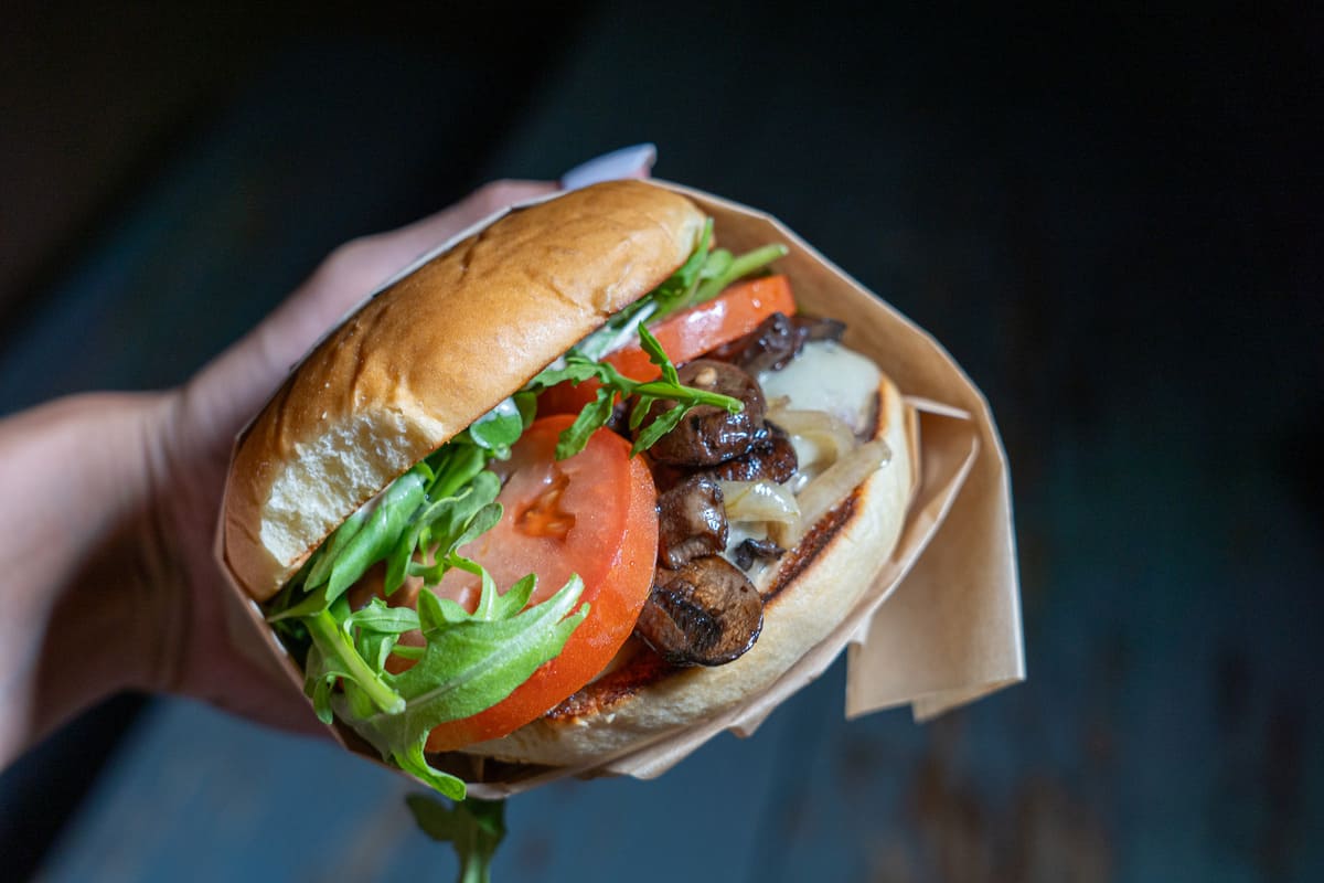 Burger with arugula, tomatoes, and other toppings