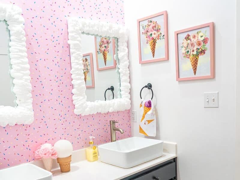 Shared bathroom with whipped cream around mirrors and wallpaper at Casa Kumwesu