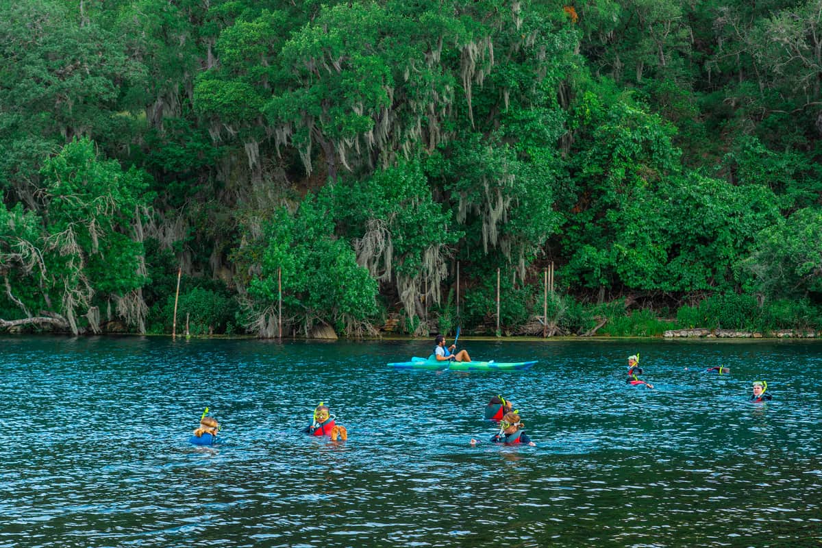 People snorkeling and kayaking on the lake