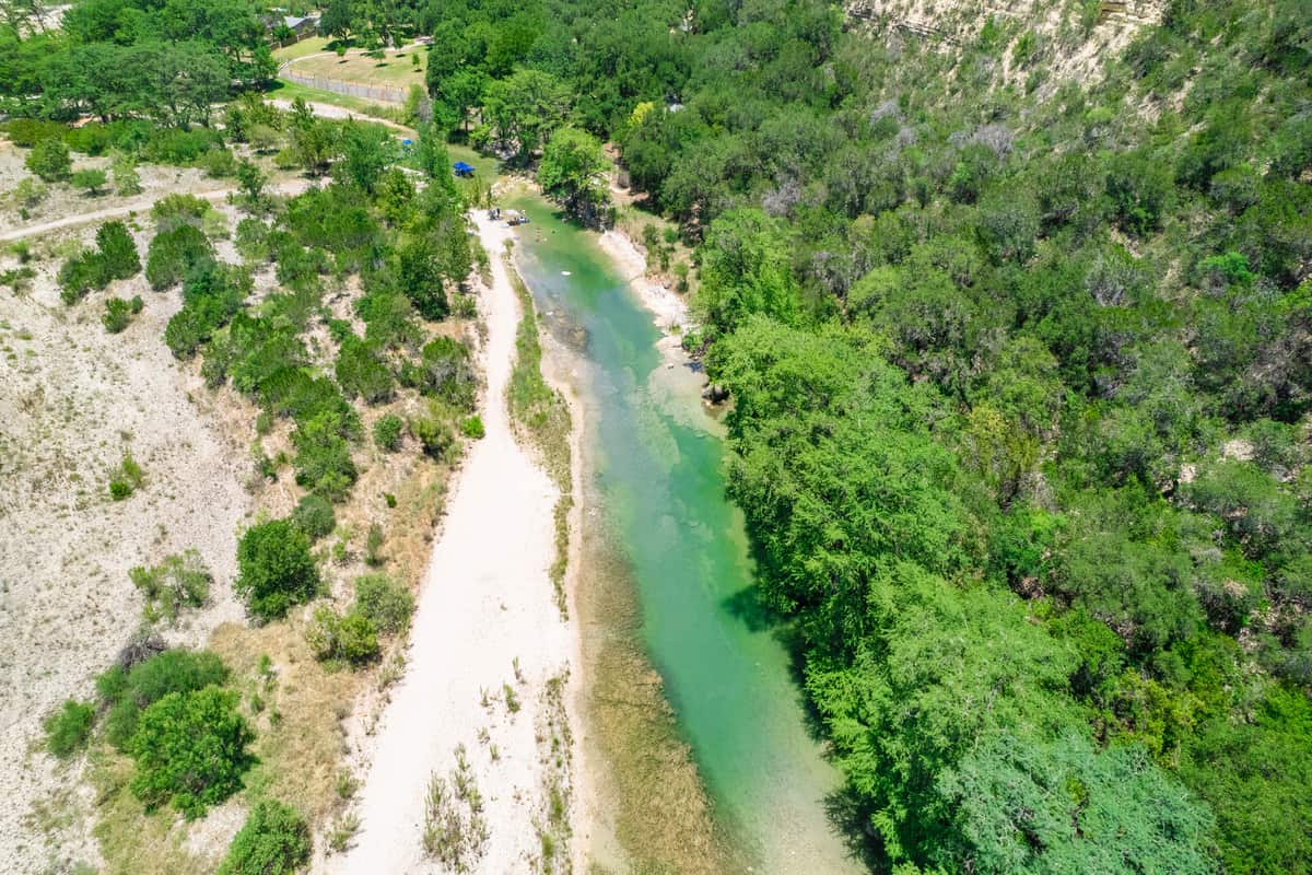 Aerial view of a river surrounded with trees.