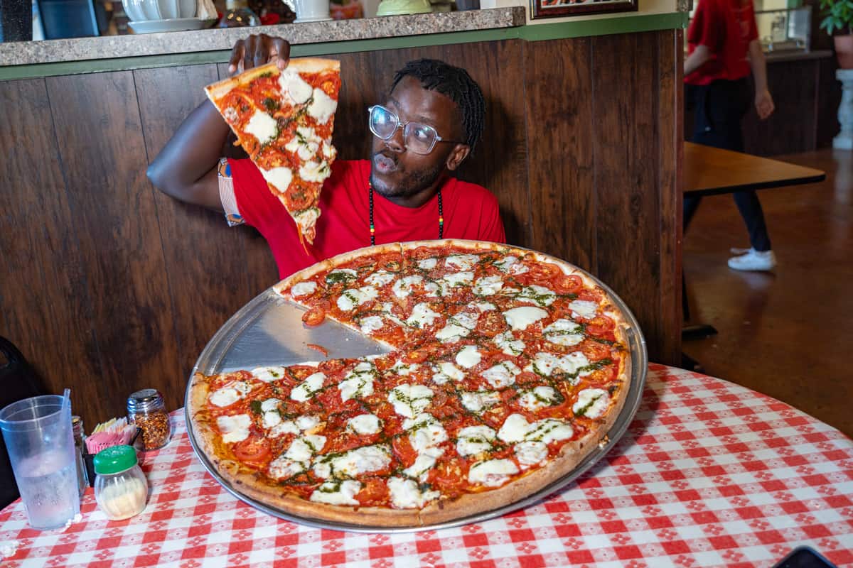 A man holding a giant pizza