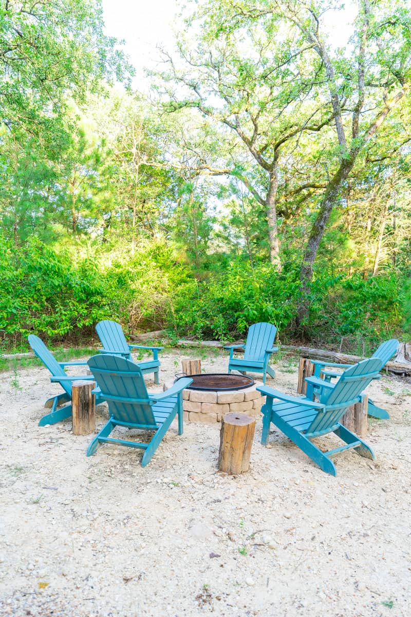 Outdoor fire pit with wooden chairs in  Elf's Aerie Treehouse