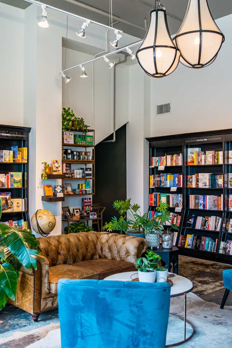 A vintage design couch with lot of books on the background.