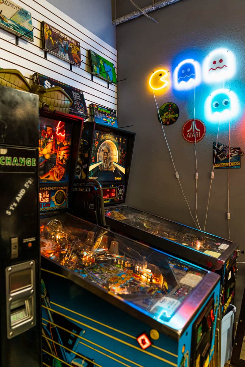 Pinball machines with Pac-Man signs on the wall