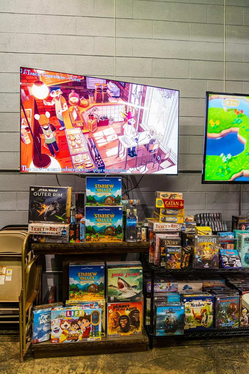 Screens with game graphics on them and board games on the shelves