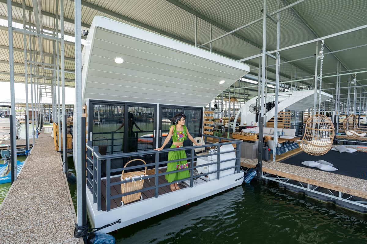 A floating room with a woman in green dress standing on a balcony.