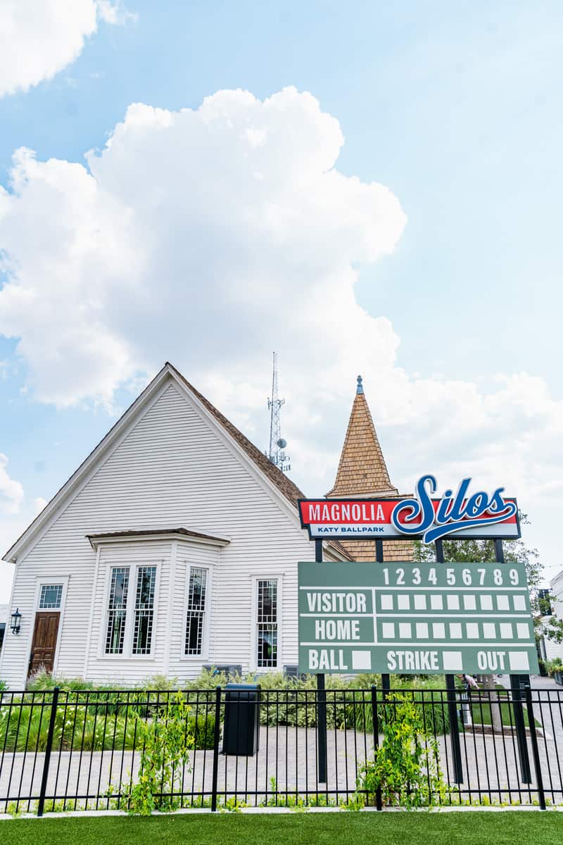 Score board on the interactive baseball field with a church in the background