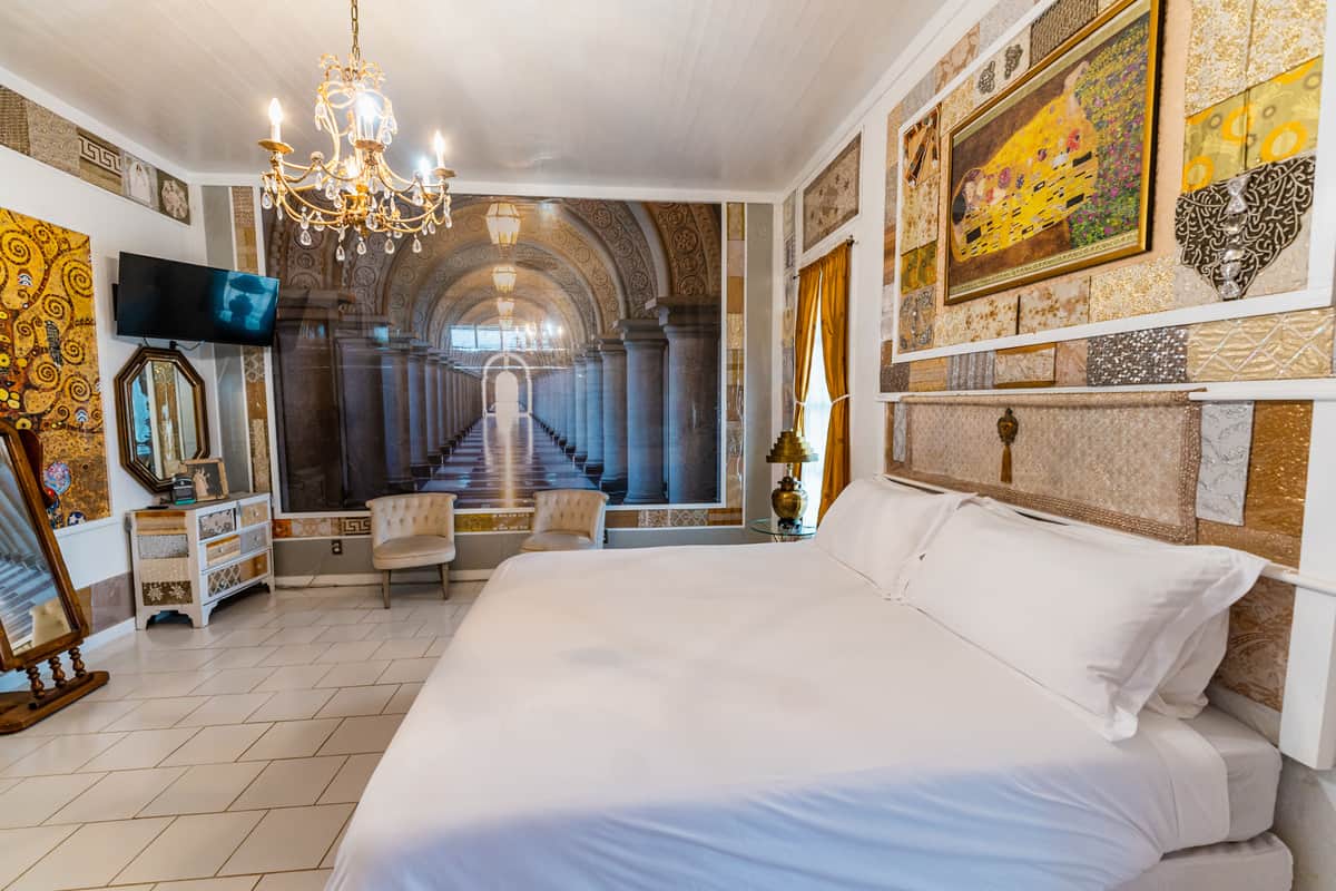 A room with king size bed with white sheets with Moroccan-inspired décor,