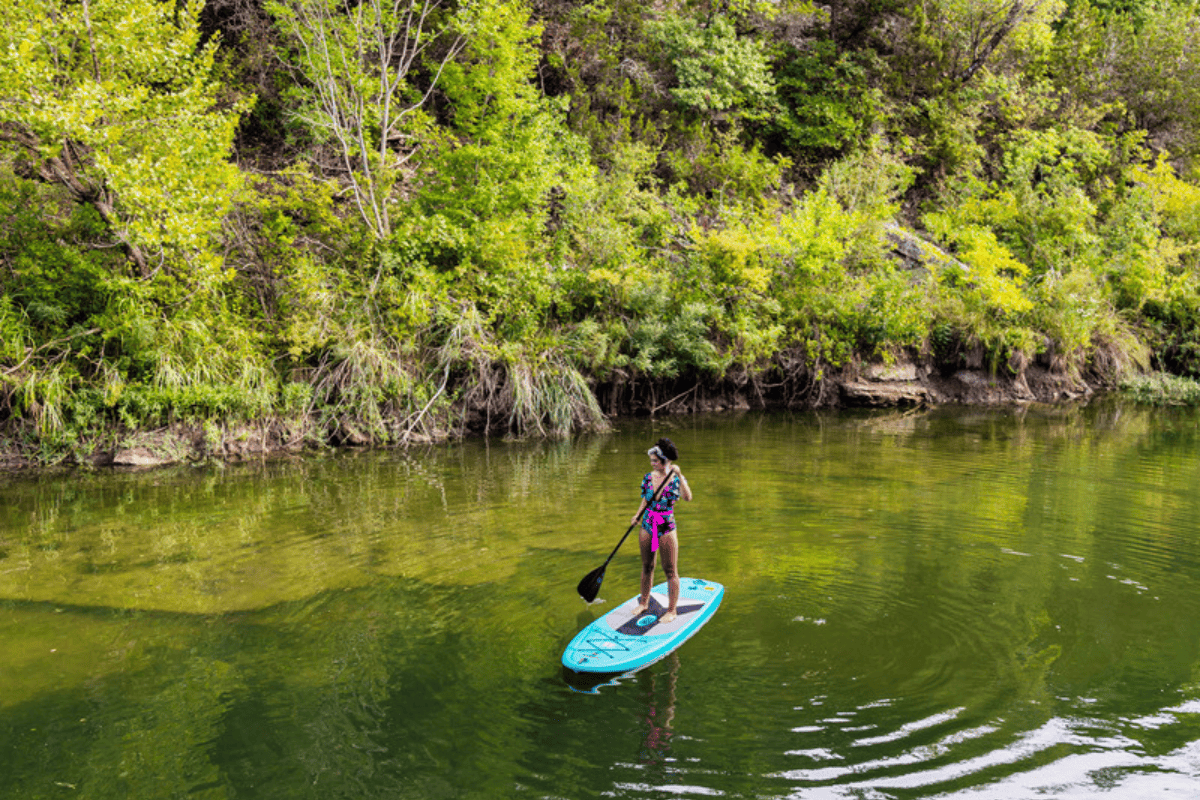 A woman on a stand up paddle board.