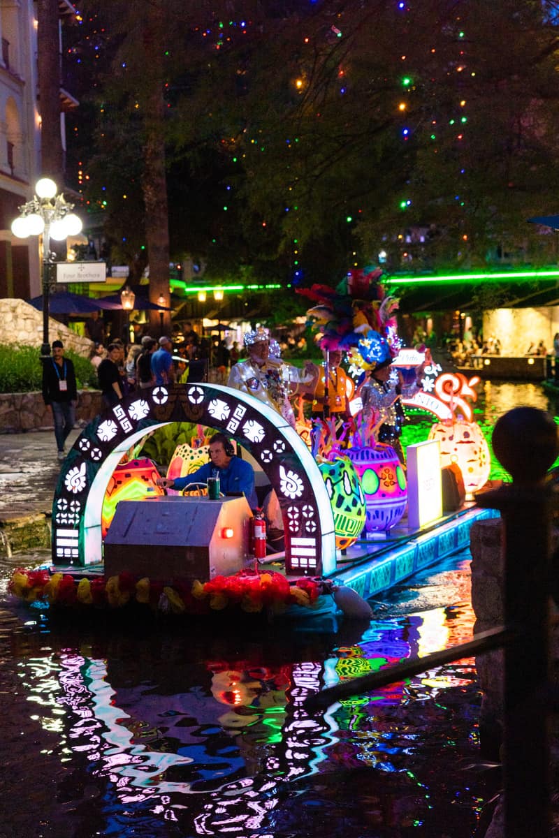 Colorful float parade on a river.