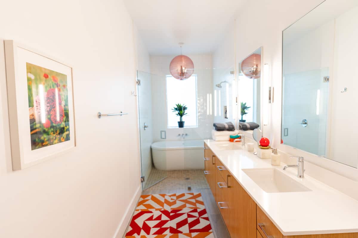 Bathroom with double sink and white showe tub. 