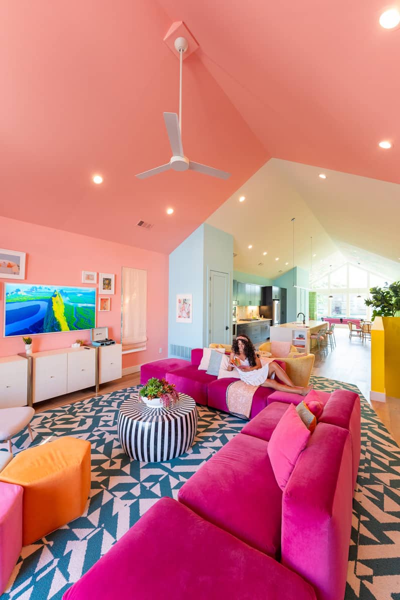 A woman relaxing on the pink couch in the living room.