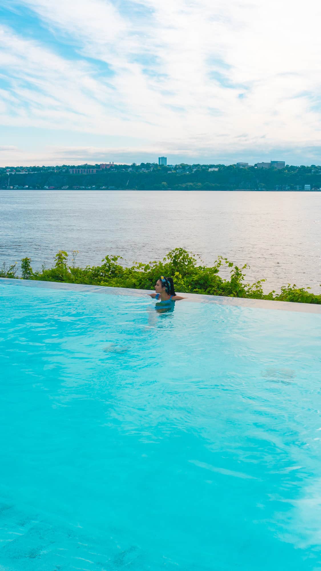 A woman swimming on an infinity pool.