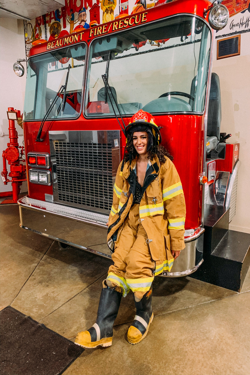 a person wearing a firefighter outfit and standing next to a fire truck