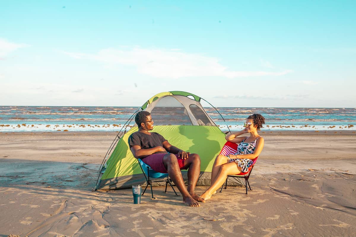 a person and person sitting in chairs on a beach