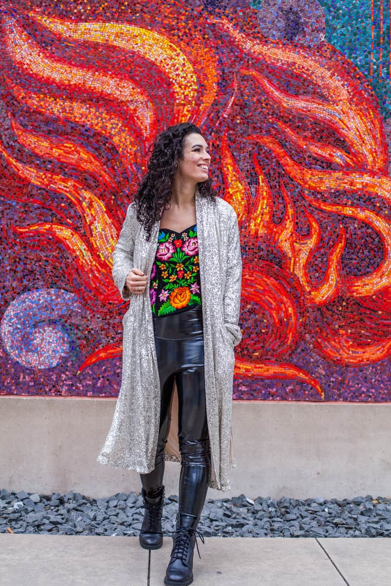 Woman standing in front of a mosaic depicting a fire in the Arts District